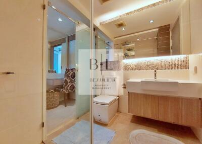 Modern bathroom with glass shower, wooden vanity, and large mirror