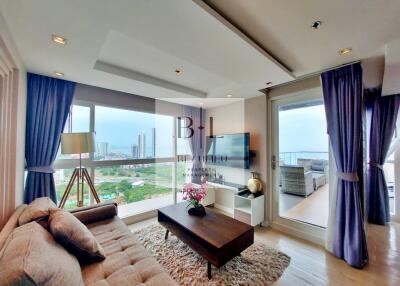 Modern living room with city view, comfortable furniture, and balcony access