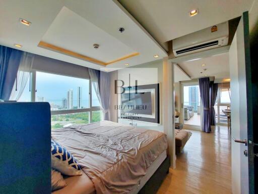 Modern bedroom with large windows and a city view