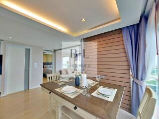 Modern dining area with table set for two, adjacent to living space