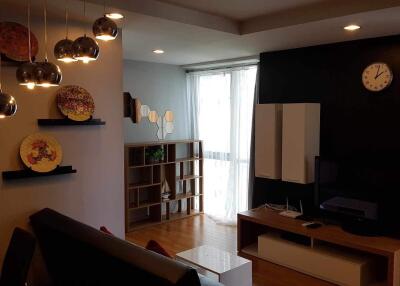 Modern living room with shelves, TV unit, and decorative lighting