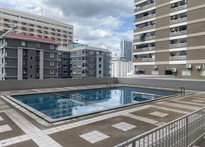 Building outdoor area with a swimming pool and high-rise apartments in the background