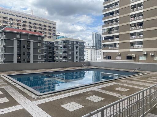 Building outdoor area with a swimming pool and high-rise apartments in the background