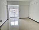 Spacious empty living room with large windows and balcony