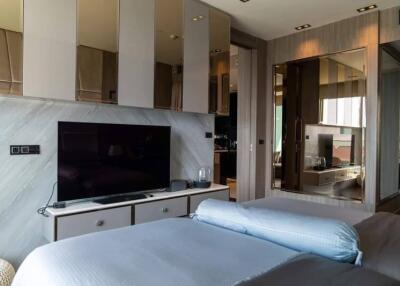 Modern bedroom with large TV and mirrored closets