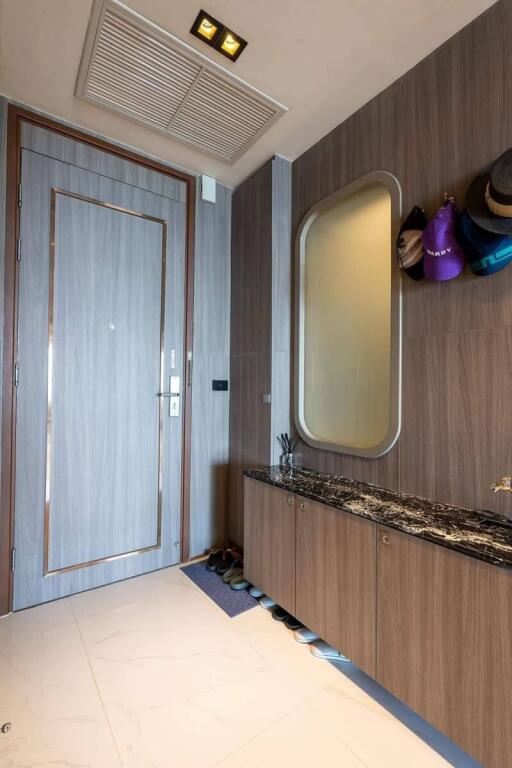 Modern entryway with wooden cabinetry and large mirror