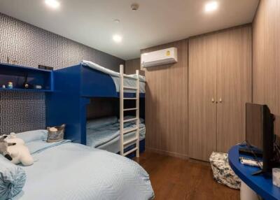 Bedroom with bunk beds, single bed, TV, and storage