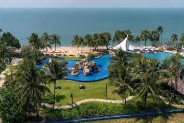 View of a luxurious outdoor pool area with beach and ocean in the background