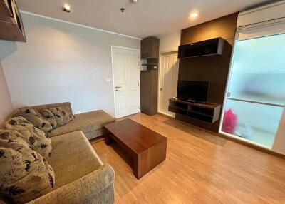 Modern living room with L-shaped sofa and wall-mounted TV