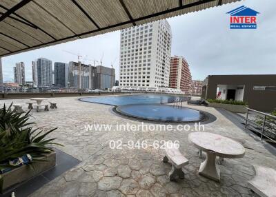 Outdoor pool area of a building with cityscape view