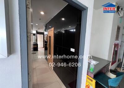 Entrance hallway view with nearby desk area and black tiled wall