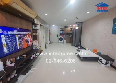 Main living area with TV, storage shelves, washing machine