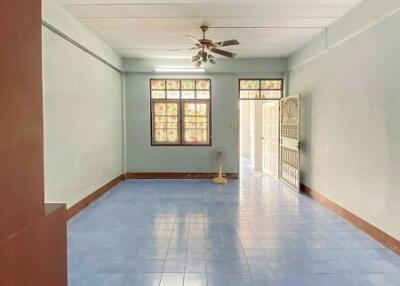 Spacious empty living area with ceiling fan and blue tiled floor