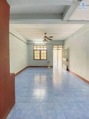 Spacious empty living area with ceiling fan and blue tiled floor