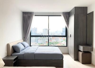 Modern bedroom with large window and city view