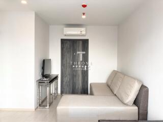 Modern living room with sofa, TV, and air conditioning