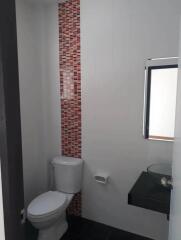 Modern bathroom with white walls and decorative red tile accent