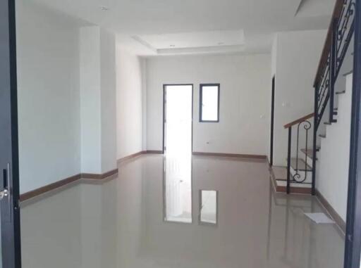 Spacious living room with shiny tiled flooring and stairs