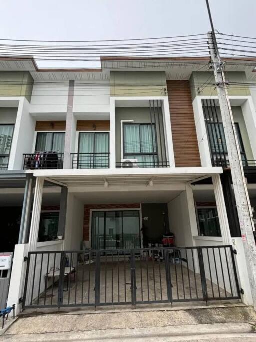 Front view of a modern townhouse with a covered driveway