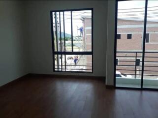 Empty living room with large windows and wooden floor