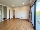 Spacious bedroom with wooden flooring and large windows