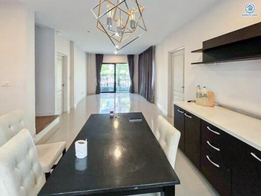 Modern dining area with black table and chandelier