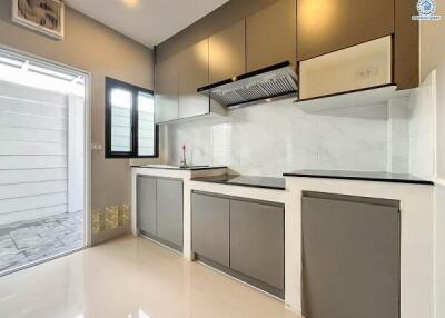 Modern kitchen with gray and white cabinetry and tile backsplash