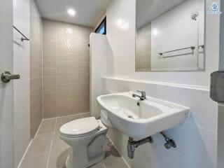 Modern bathroom with a walk-in shower, toilet, and wall-mounted sink