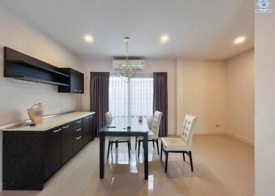 Modern dining area with table set for four, cabinets, and large window