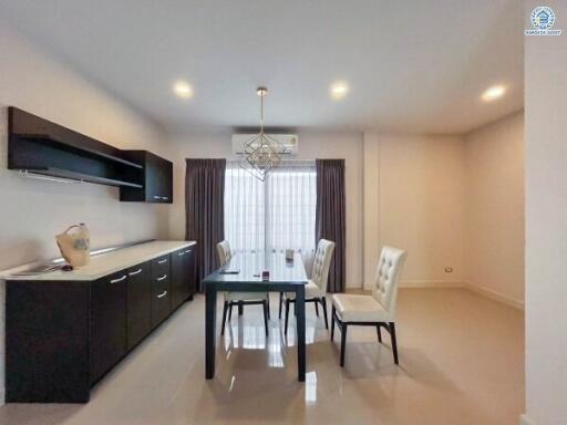 Modern dining area with table set for four, cabinets, and large window