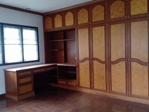 Spacious bedroom with built-in wooden wardrobe and study desk