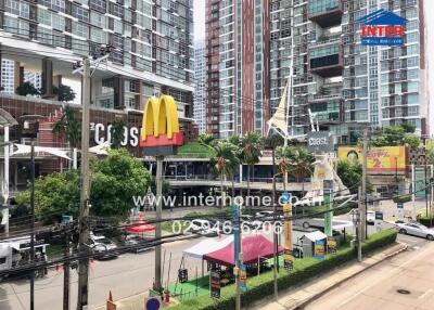 Street view of a vibrant urban area with high-rise buildings and commercial establishments.