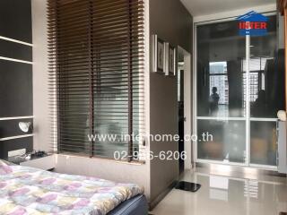 Bedroom with large window and view of neighboring buildings