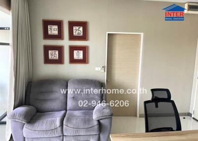 Living room with grey sofa and office chair