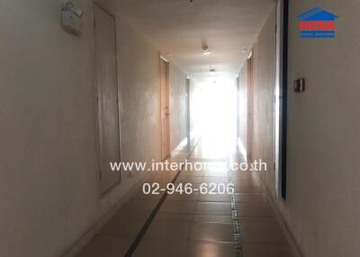 Hallway with tile flooring and lighting