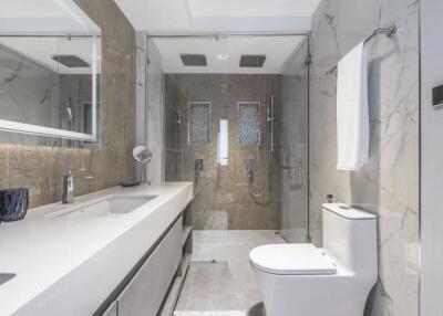 Modern bathroom with large mirror, shower, and toilet