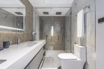 Modern bathroom with large mirror, shower, and toilet