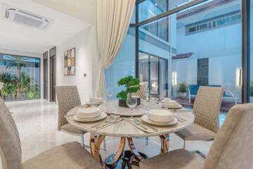 Modern dining room with elegant setting and large windows.