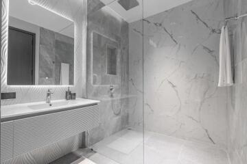 Modern bathroom with marble tiles and glass shower enclosure