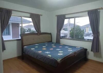 Bedroom with large windows, double bed, and hardwood floor