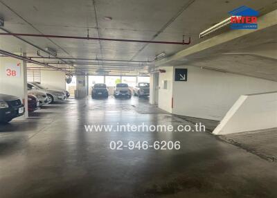 Underground parking space with multiple parked cars and clear directional signs