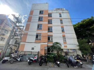 Exterior of a multi-story apartment building with parking space