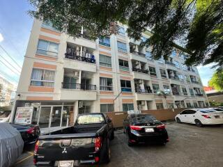 Front view of an apartment building with parked cars