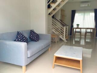 Modern living room with stairs and dining area