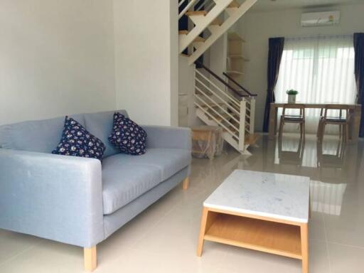 Modern living room with stairs and dining area