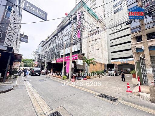 Street view of commercial buildings with signage and contact information