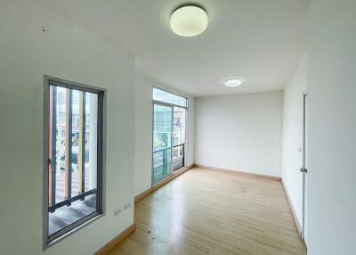 Spacious and bright empty room with large windows and wooden flooring