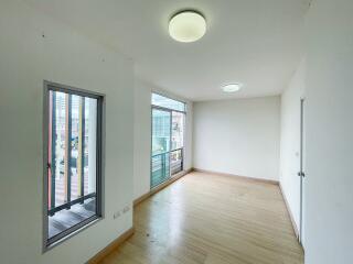 Spacious and bright empty room with large windows and wooden flooring