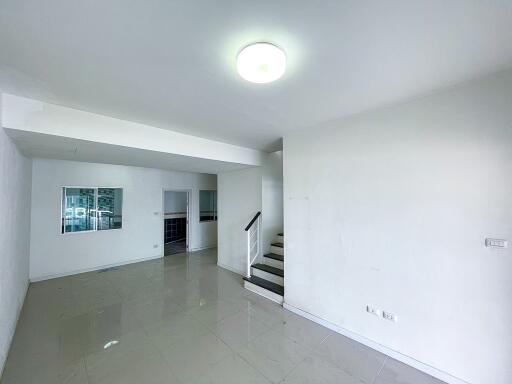 Spacious living room area with natural lighting and tiled flooring