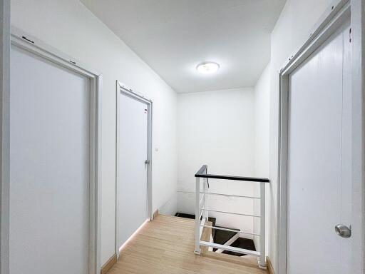 Well-lit hallway with multiple doors and stairway